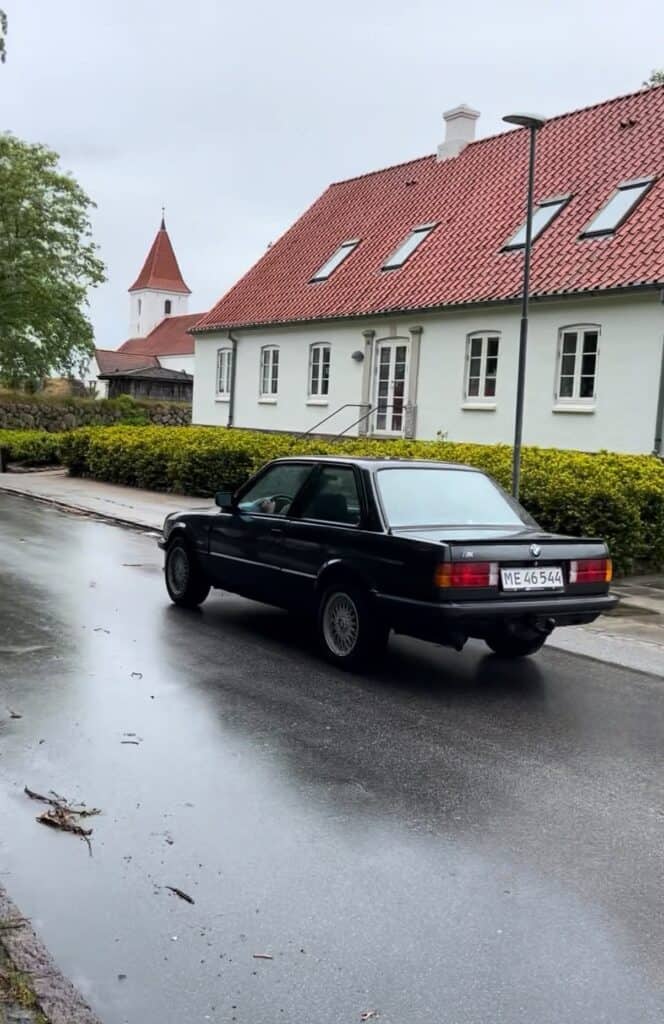 Eddis sorte BMW E30 320i set bagfra på en våd vej